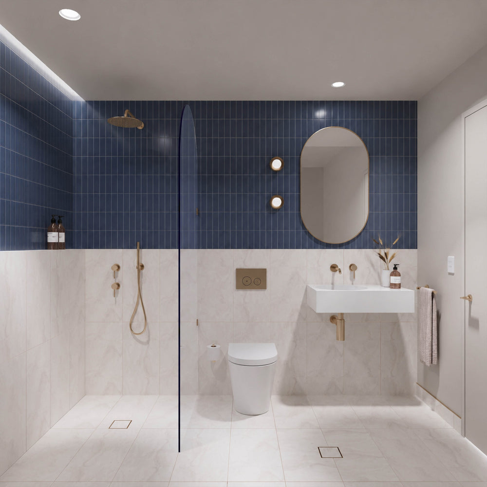 Navy and white marble-look tiled bathroom with walk-in shower, white wall-hung basin, pill-shaped mirror and gold fittings