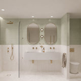 Large sage green and white marble-look tiled bathroom with double white basin, two pill-shaped mirrors and walk-in shower