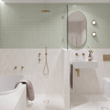 Long sage green and white marble-look tiled bathroom with tiled-in bath, walk-in shower and white wall-hung basin