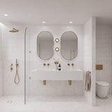 Large white tiled bathroom with marble-look tiles, double white basin, two pill-shaped mirrors and walk-in shower