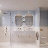 Large light blue and white marble-look tiled bathroom with double white basin, two pill-shaped mirrors and walk-in shower