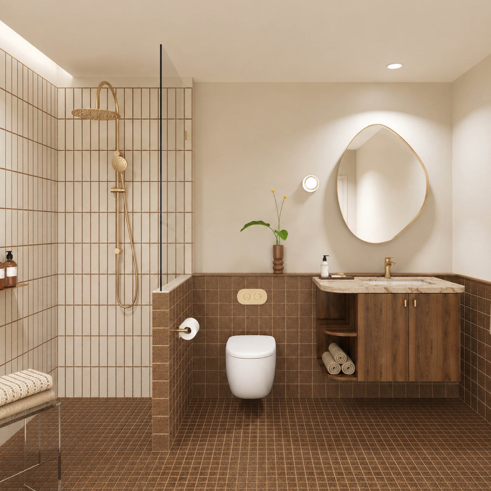 Terracotta tiled bathroom with walk-in shower, timber vanity, cream stone benchtop, pebble-shaped mirror and gold fittings